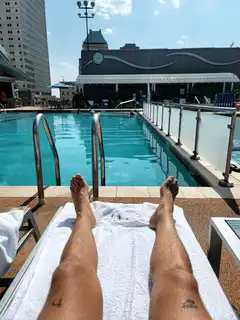 POV relaxing legs by pool