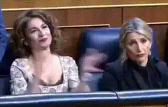 Woman clapping enthusiastically next to bored woman