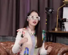 Woman in white glasses gestures and adjusts them