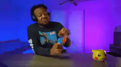 Man playing with toy gun and Pikachu