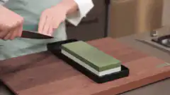 Person sharpening a knife on a whetstone