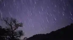 Time-lapse of star trails over a hill