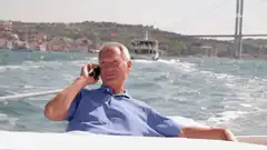 Older man talking on phone on a boat