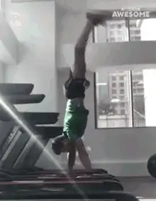 Man doing handstand on treadmill