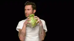 Adam Levine eating lettuce