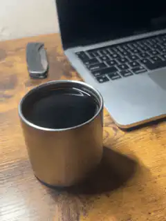 coffee cup on desk next to laptop