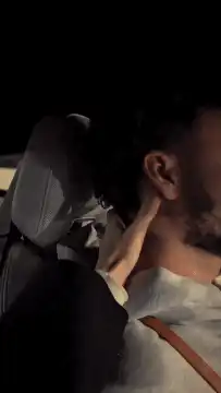 Hand caressing man's neck in car