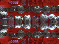 shiny metallic beads on red background