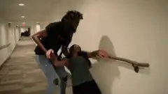 Man drags woman by arm down hallway