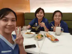Three women eating sushi and smiling