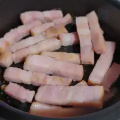 raw bacon strips in a pan