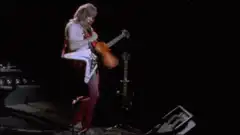 Brian May plays violin on guitar