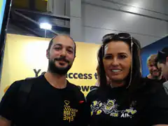 Man and woman at event with yellow banner