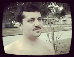 shirtless man with mustache and woman in blue robe