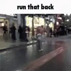 Shirtless man runs down wet street