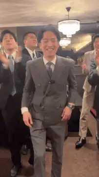Man in grey suit dancing excitedly