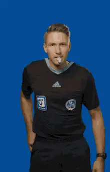 Soccer referee blows whistle and shows red card