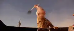 man swinging shovel in desert
