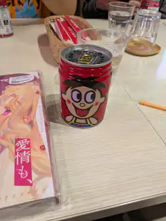 Ajinomi Red Can and Manga on Table