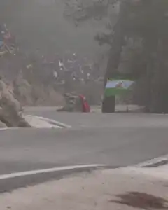 Rally car drifts around foggy corner