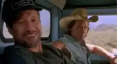 Two men in a truck, one smiling