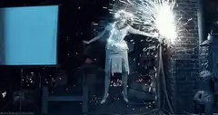 Woman holding sparklers in dark room