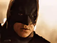 Batman gliding through a burning building
