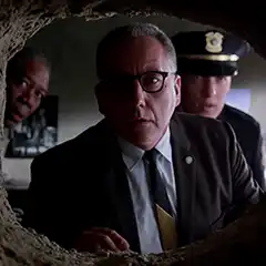 Men looking through a hole in the wall