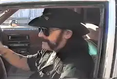 Man in car lifts sunglasses