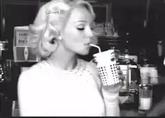 blonde woman sips drink with straw