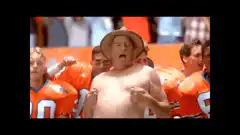 Shirtless man in hat cheering at football game