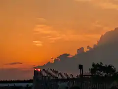 sunset behind clouds and fence