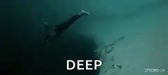 Diver falling into deep dark water
