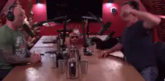 Two men talking at a podcast table