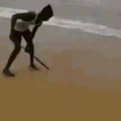 Man sweeping sand on beach