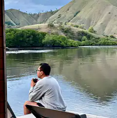 man drinking coffee on boat