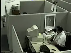 Man typing in office cubicle
