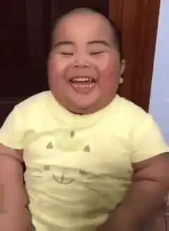 Laughing baby in yellow shirt