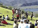 Crowd jumping on a grassy hill