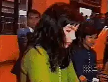 Woman in green shirt gets hit by camera