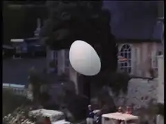 Giant white balloon rolls through park