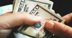 Hands counting fifty dollar bills