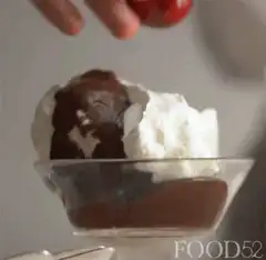 Hand placing a cherry on ice cream