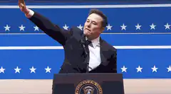 Elon Musk waving at podium