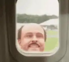 Man smiling out of a train window
