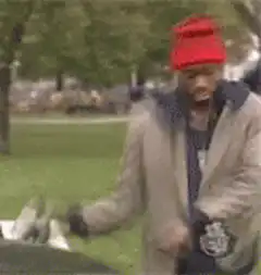 Man in red beanie dancing in park