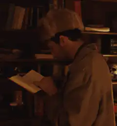 Man in fur hat reading book