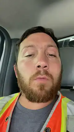 man in safety vest looking tired