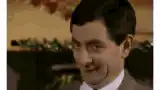 Rowan Atkinson smirking and talking