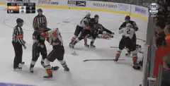 Hockey players fight near the boards